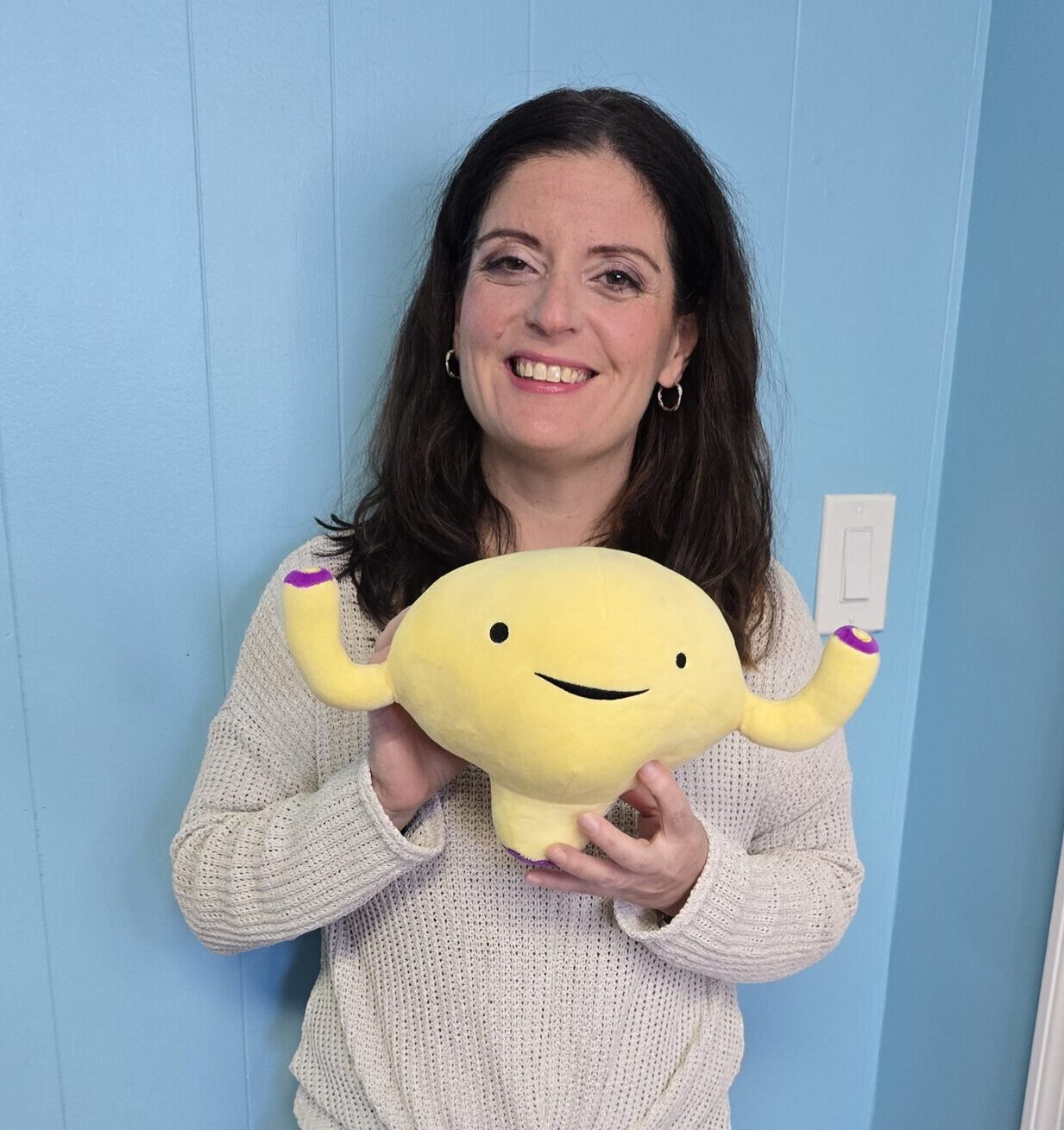 Pelvic health provider holding anatomical bladder model, representing cash-based pelvic physical therapy practice growth and healthcare business coaching support through PelviBiz